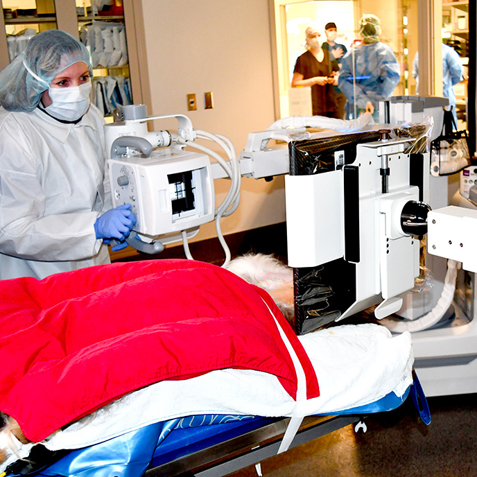 Technician walking with mobile x-ray machine