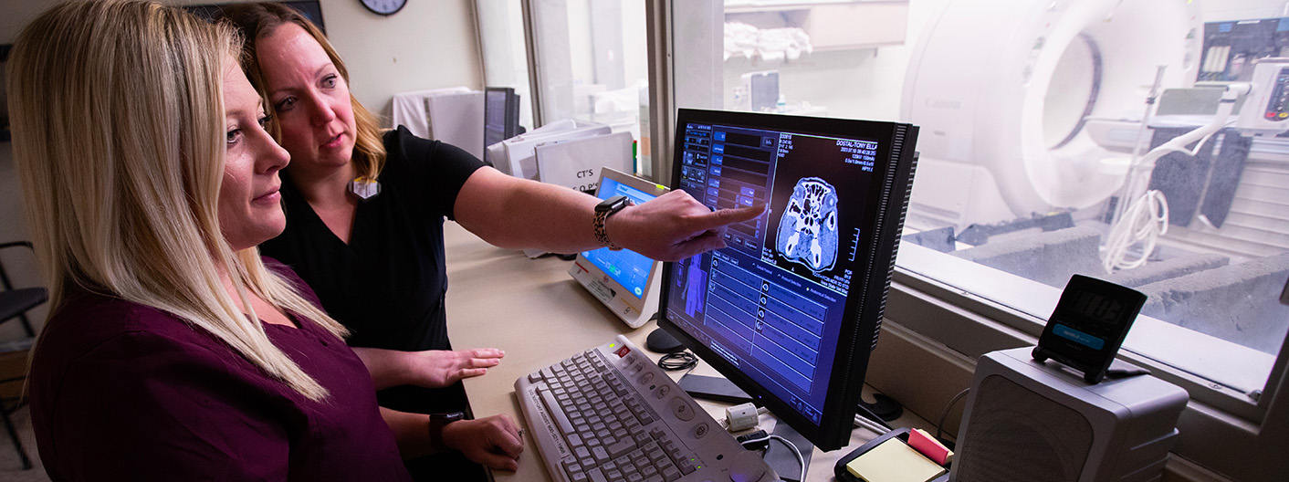 technicians reviewing CT scan